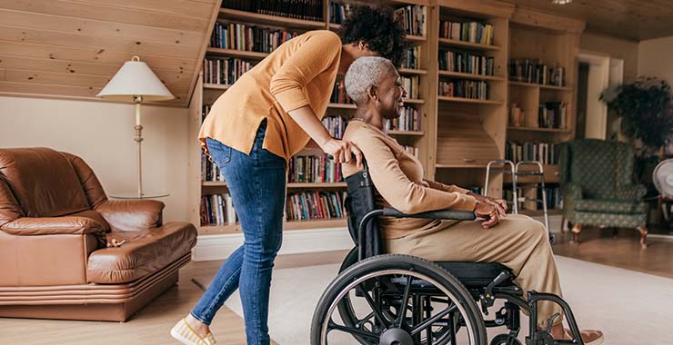 Woman pushing elderly mother in wheelchair