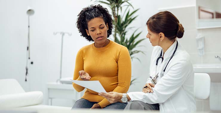 Black woman speaking with doctor