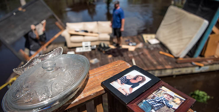 man surveys flood damage and debris