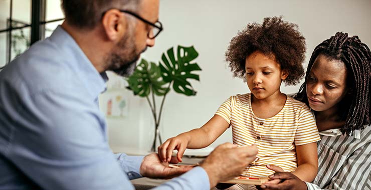 Black mother and daughter interacting with psychologist