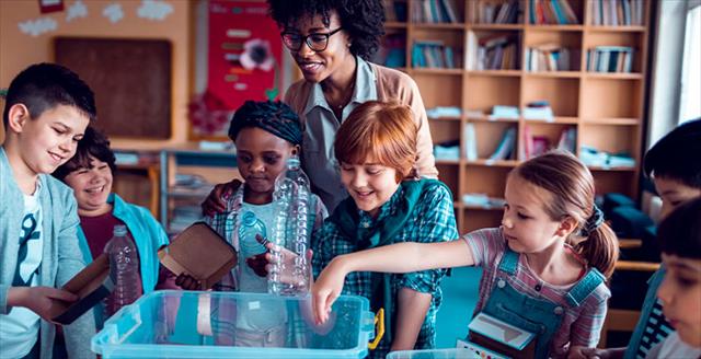 Teacher doing an experiment with young students in a classroom