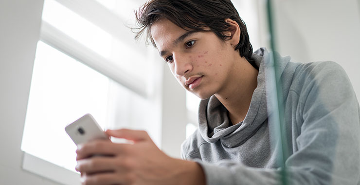 Teenage boy looking at cellphone