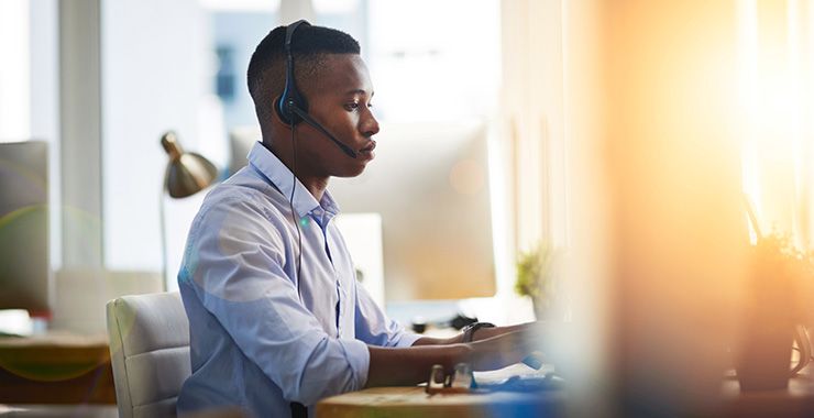 Man at desk wearing a headset