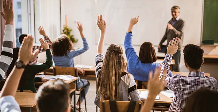 Kids raising their hands in a classroom