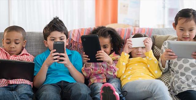 Little kids looking at electronic devices