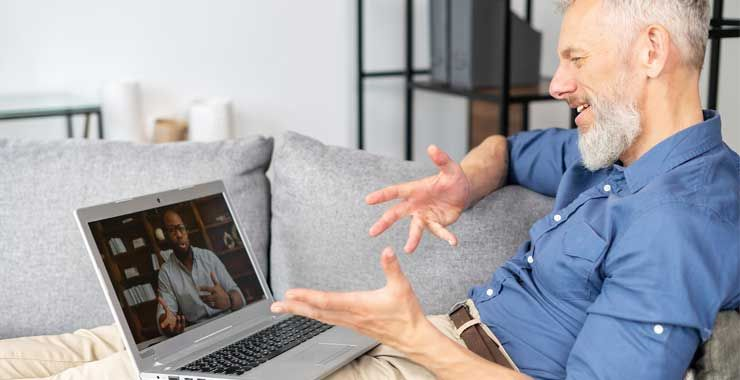 Middle-aged man using his laptop to engage in a video call with a health professional
