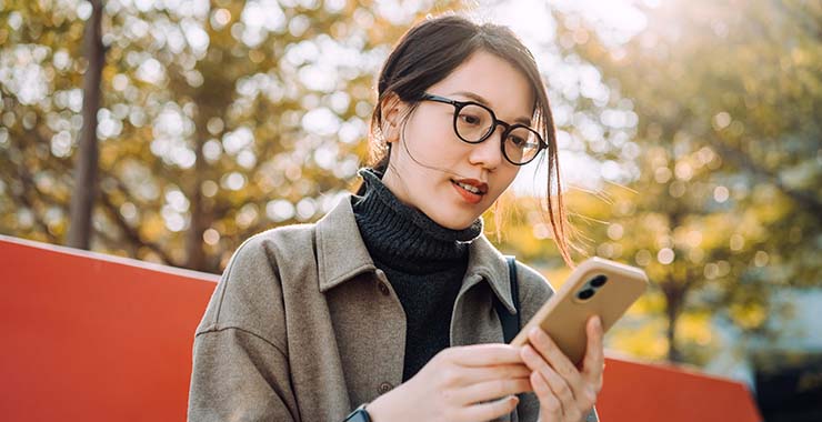 Woman outside looking at smartphone