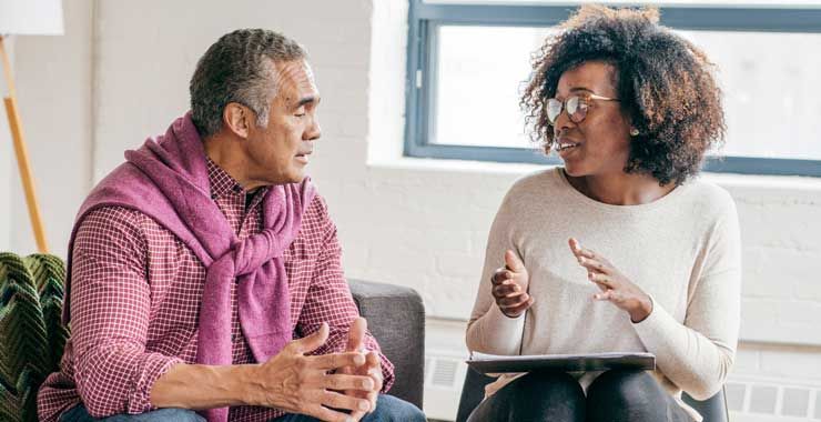A psychologist meeting with an older adult in an office setting