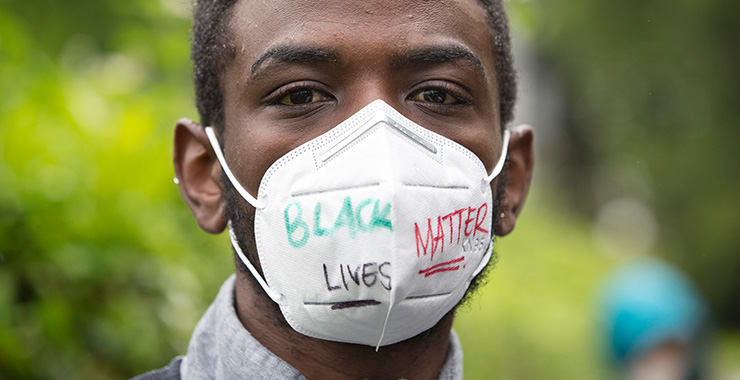 Black man wearing a face mask with ‘Black Lives Matter’ written on it
