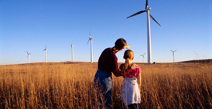 adult and child observing wind turbines
