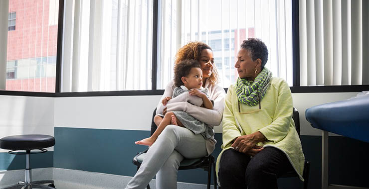 grandmother, mother, and daughter sitting in a medical office waiting room