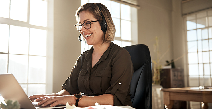 smiling person sitting at portable computer